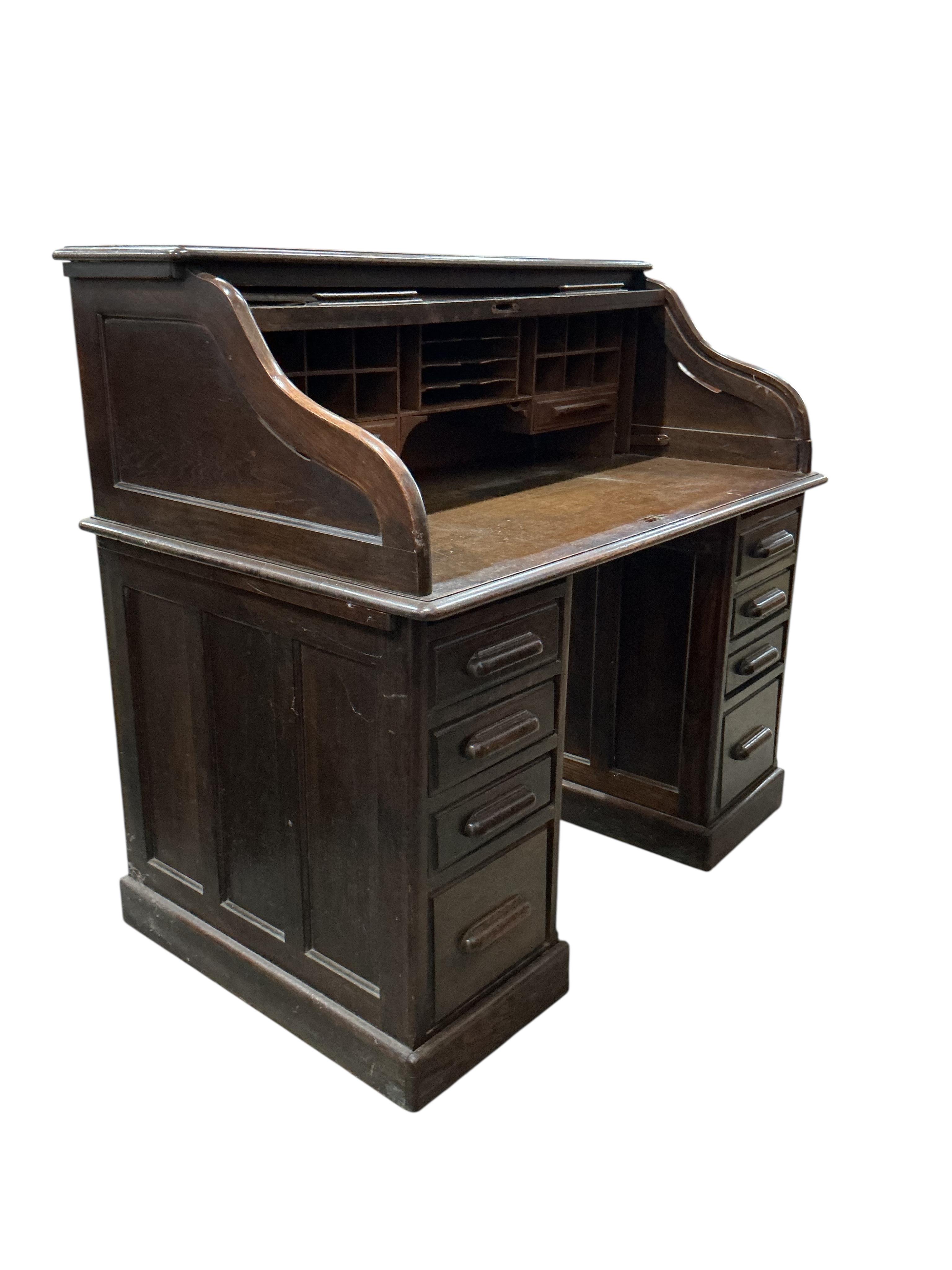 An early 20th century oak 'S' shaped tambour roll top desk, width 124cm, depth 78cm, height 120cm